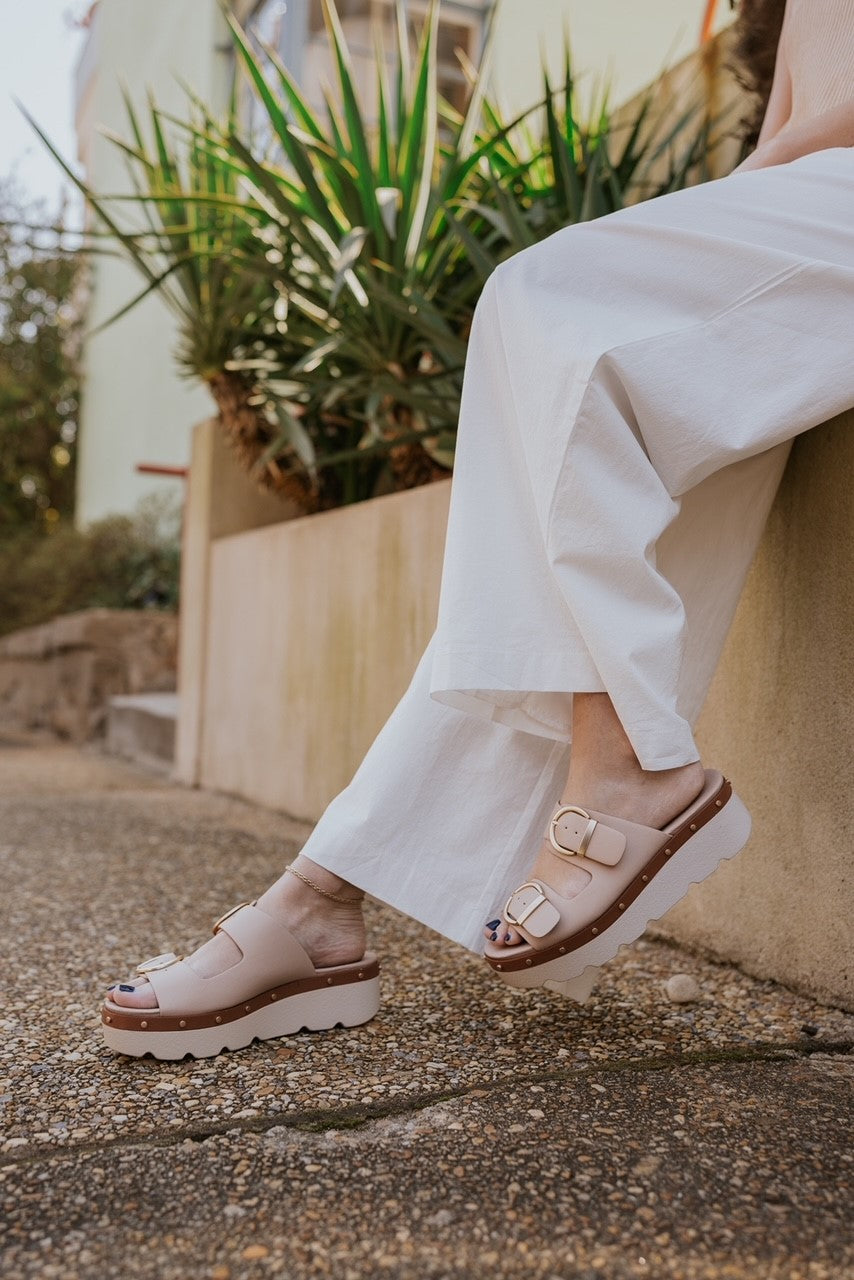 Front right angle view of Surfs Up Sandal in Beige which features contrasting platform sole and side-stitching, two eye-catching vamp straps with oversized buckles, and an ultra-comfortable footbed and 2.5" Heel 1.5" Platform.