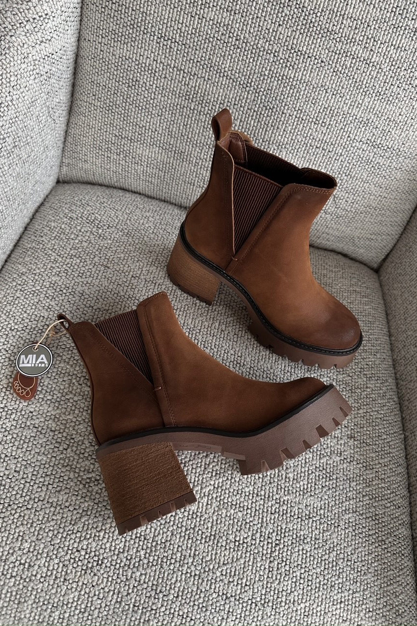 Flat lay view of Rusty Bootie in Cognac which features cognac suede fabric, round neckline, platform sole, block heel, and pull tabs