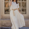 Full body view of model wearing the Amelia Off White Midi Skirt which features ivory light weight fabric, midi length, ivory lining, a monochrome pattern design, two slit side pockets, and an elastic waistband.