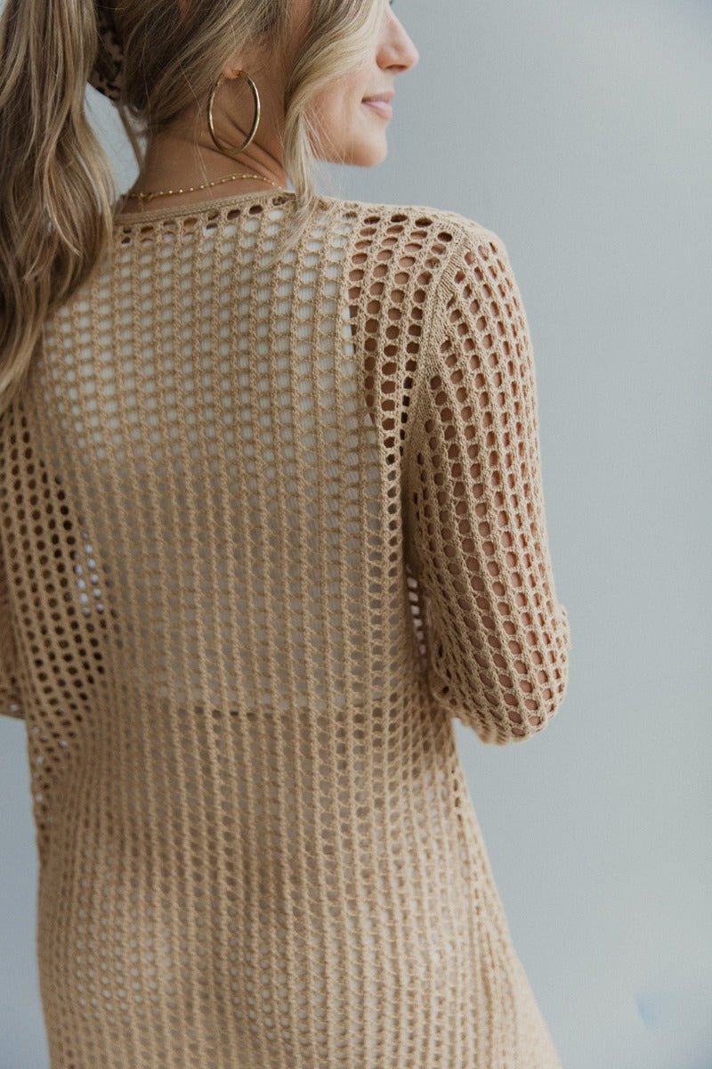 Close up back view of model wearing the Speak For Yourself Cardigan which features light taupe open knit fabric, a front tie closure and long sleeves.