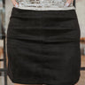 Close front view of The Static Radio Skirt In Black features black suede fabric, lining details, mini length, and elastic waistband.