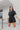 Frontal view of the Heading South Romper that features a black colored material, a collar neckline, a short cuffed sleeve, a button-up front, two front pockets at the chest, a cinched waist, two side pockets, cuffed bottom hem, and two back pockets.
