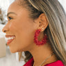Side view of model wearing the You Give Me Joy Earrings in Red is a an open hoop style earring, featuring red textured frills.