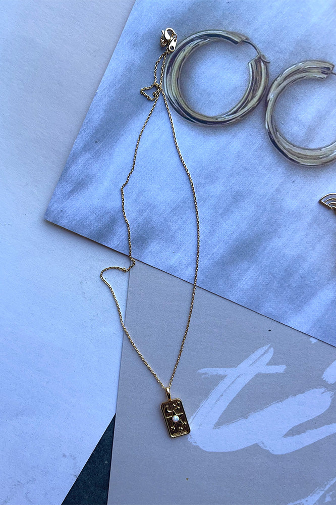 The Hang The Moon Necklace is a gold necklace, featuring a gold link with a square pendant finished with a clasp closure.