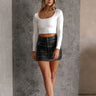 Full body front view of model wearing the Greta Ivory Basic Long Sleeve Crop Top that has ivory knit fabric, a cropped waist, a thick band hem, a square neckline and long sleeves.