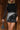 Front view of model wearing the Zara Black & Silver Sequin Mini Skirt which features black sequin and silver sequin fabric, colorblock design, black lining, mini length and back zipper.