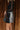 Side view of model wearing the Zara Black & Silver Sequin Mini Skirt which features black sequin and silver sequin fabric, colorblock design, black lining, mini length and back zipper.