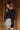 Back view of model wearing the Zara Black & Silver Sequin Mini Skirt which features black sequin and silver sequin fabric, colorblock design, black lining, mini length and back zipper.