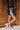 Full body side view of model wearing the Zara Black & Silver Sequin Mini Skirt which features black sequin and silver sequin fabric, colorblock design, black lining, mini length and back zipper.
