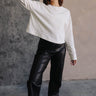 Full body view of model wearing the Nikole Cream Cropped Long Sleeve Sweatshirt which features cream cotton fabric, cropped waist, round neckline and long sleeves.