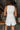 Back view of model wearing the Never Out Of Style Romper which features white fabric, side pockets, a sleeveless design, a round neckline, and a monochromatic back zipper with a hook closure.