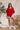 Full body view of model wearing the Let's Dance Ruffle Sleeve Top that has red semi-sheer fabric, a round neckline, ruffle tiered short sleeves, and a back keyhole with a button closure.