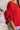 Close up view of model wearing the Let's Dance Ruffle Sleeve Top that has red semi-sheer fabric, a round neckline, ruffle tiered short sleeves, and a back keyhole with a button closure.