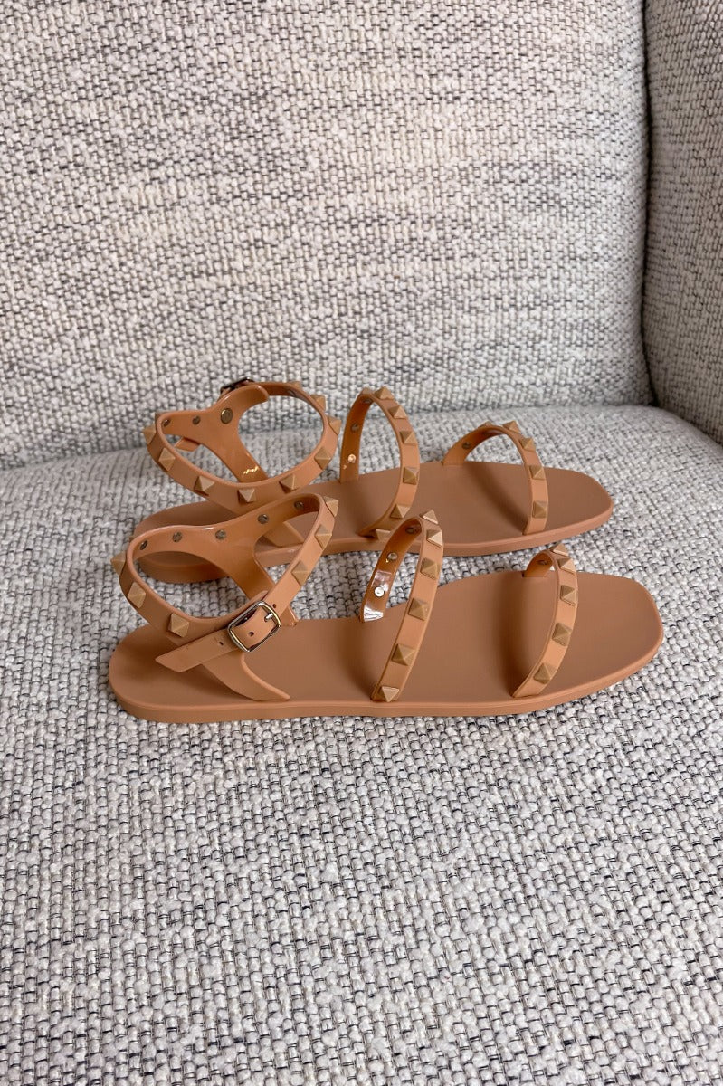 Right side view of the Now or Never Sandals which features matte peach coloring, pc upper, monochromatic studs and adjustable buckle straps. 
