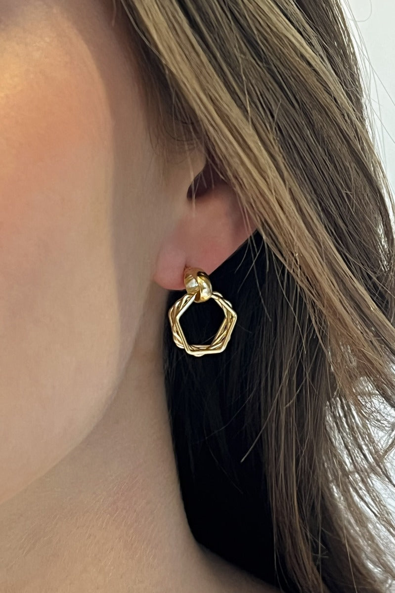 Close-up of model wearing the Here We Go Earrings feature mini gold dimensional hoops with roping designs.