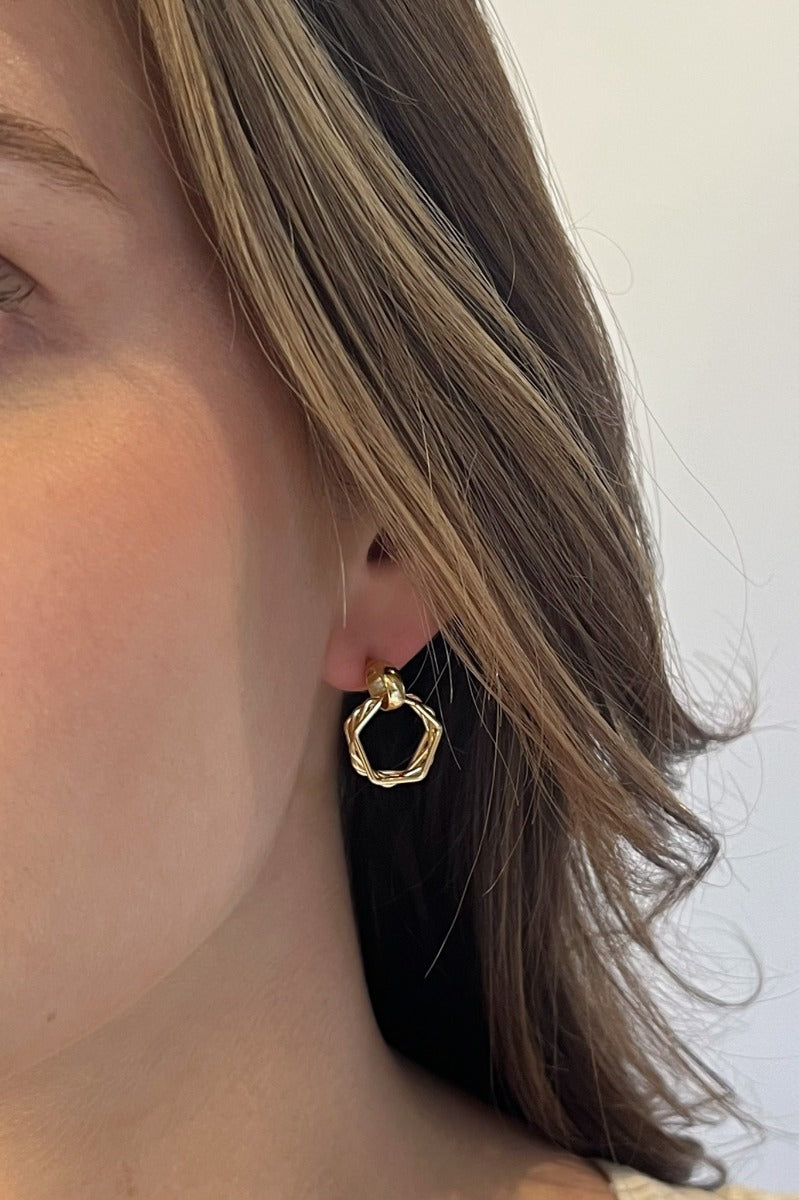 Close-up of model wearing the Here We Go Earrings feature mini gold dimensional hoops with roping designs.