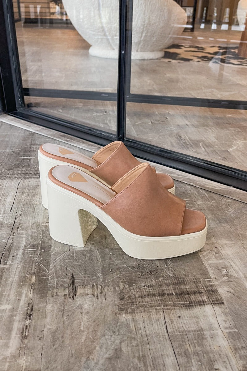 Side view of the Sienne Block Heel which features a slip-on style, two-tone design, white sole with a block heel and nude/pink upper.