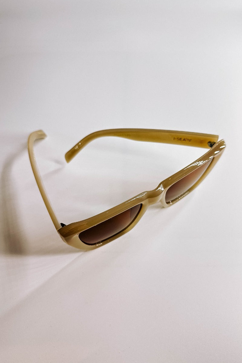 Ariel view of the I-Sea: Ava Sunglasses in Oatmeal & Brown which features light taupe frames with brown lenses.