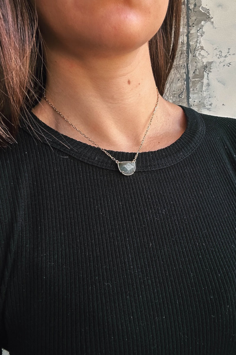 Front view of model wearing the Naomi Grey Stone Gold Necklace which features single gold chain layer with a charcoal grey stone.