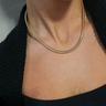 Close up view of model wearing the Emilia Gold Slinky Single Layer Necklace which features single gold slinky layer with adjustable clasp closure.