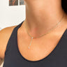 Close up view of model wearing the Beautiful and Free Necklace which features gold chain link lariat with two clear stones connected by gold chain links.