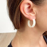 Side view of model wearing the Keep It Simple Earrings in Ivory which features small, open hoops with cream tortoise design.
