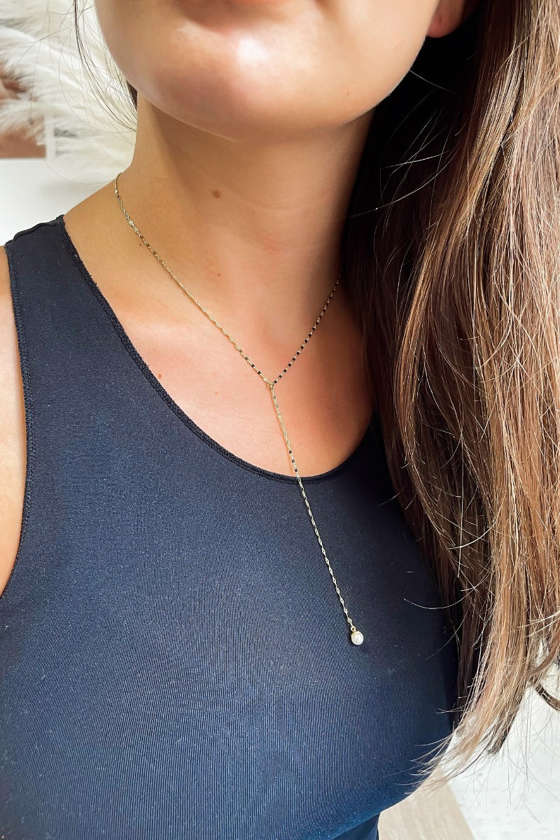 Front view of model wearing the I Like Your Soul Necklace which features gold chain link lariat with a pearl medallion linked by another gold chain.