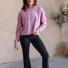 full body front view of model wearing The Chloe Purple Hoodie Long Sleeve Sweatshirt that has light purple cotton fabric, a thick hem, a high neckline with a hood attached and drawstring ties, dropped shoulders, and long sleeves with cuffs.
