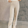 front view of model wearing the Destiny Oatmeal Knit Pants that have oatmeal knit fabric, a ribbed elastic waistband, and wide legs. 