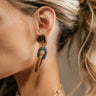 Side view of model wearing the Naomi Neutral Link Earrings that feature dark olive tortoise studs attached to grey and light brown oval chain links.