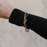 Image of model's wrist with the Lennon Gold Chain Toggle Bracelet that features one layer with gold beads and one layer with gold chain links joined togther by a toggle clasp.