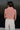 Back view of model wearing the Jordyn Orange & White Sleeveless Turtleneck Sweater which features orange and white cable knit fabric, a cropped waist, a turtleneck neckline, and a sleeveless design.