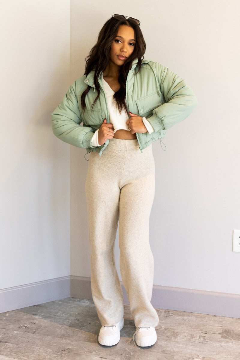 Full body front view of model wearing the Mckinley Mint Cropped Puffer Jacket that has mint green puffer fabric, a cropped waist, a front zipper with snaps, a hood, and long sleeves.