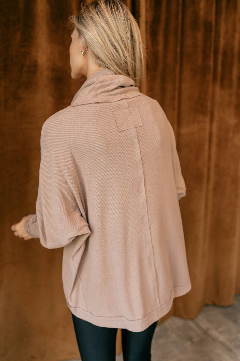Back view of model wearing The Luca Mocha Turtleneck Top features mocha knit fabric, high neckline, textured details and long sleeves.