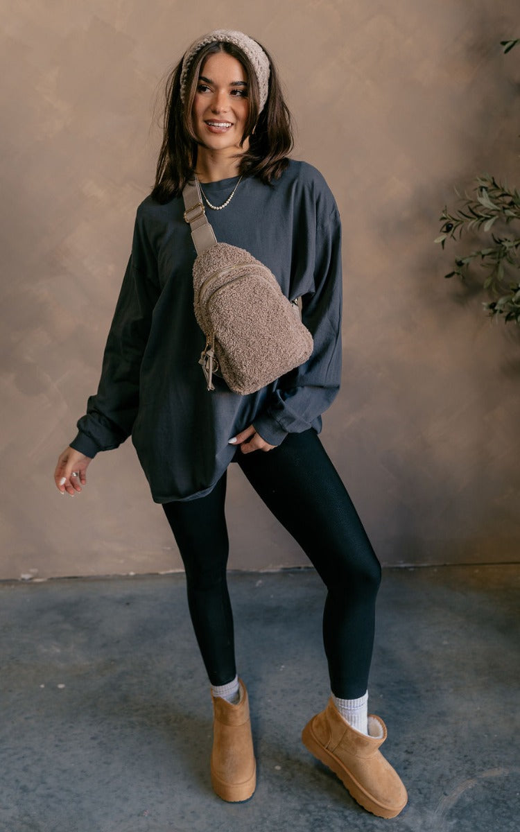 Full body view of model wearing the Vira Black Long Sleeve Sweatshirt which features washed black knit fabric, a round neckline, dropped shoulders, and long sleeves with cuffs.