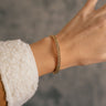 Front view of model wearing the Penelope Gold Braided Bangle Bracelet which features gold bangle with braided details.