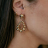 Side view of model wearing the Nora Gold Beads Teardrop Earring which features teardrop shaped dangle earrings with gold beads.