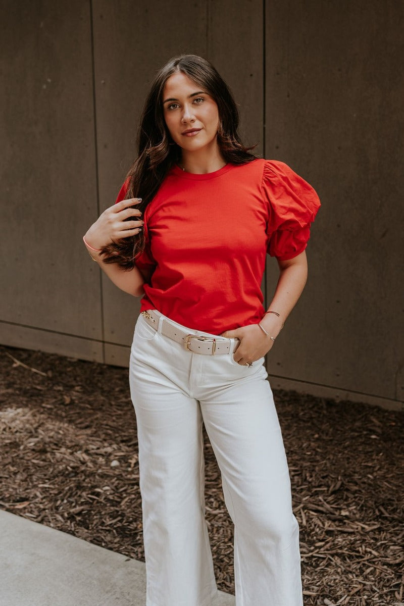 Front view of model wearing the Maddie Red Puff Sleeve Top that features red cotton fabric, a round neckline, and short bubble puff sleeves.