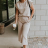Full body view of model wearing the Ella Light Taupe Cropped Pants which features light taupe knit fabric, monochrome block stripe design, elastic waistband, two front slit pockers and cropped wide pant legs.