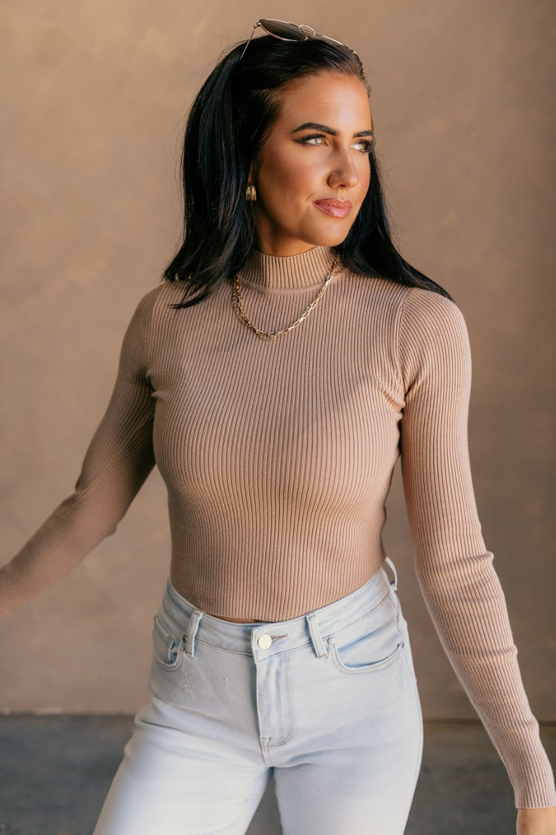 Front view of model wearing the Mila Khaki Ribbed Long Sleeve Top which features khaki ribbed knit fabric, a high neckline, and long sleeves.