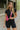 Front view of model wearing the Bring It On Romper that has black stretchy fabric, a romper body, a monochromatic front zipper, a round neckline, and short sleeves.
