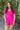 Front view of model wearing the Wishful Thinking Romper which features fuchsia fabric, a ruffle-tiered skirt, fuchsia shorts lining, an elastic waistband, a sweetheart neckline and short puff sleeves.
