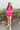 Full body view of model wearing the Wishful Thinking Romper which features fuchsia fabric, a ruffle-tiered skirt, fuchsia shorts lining, an elastic waistband, a sweetheart neckline and short puff sleeves.
