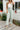 Front view of model wearing the Cross Road Jeans in Mint Green which features light sage green denim fabric, two front pockets, two back pockets, a front zipper with a monochromatic button closure, belt loops, wide legs and raw hems.