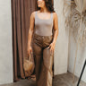 Full body front view of model wearing the Ready To Go Bodysuit In Mocha that has mocha brown knit fabric, a square neckline, a sleeveless body, and a thong bottom with snap closures