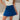 Front view of model wearing the Roll With It Skirt which features royal blue fabric, pleated details, royal blue shorts lining and a monochromatic side zipper with a hook closure.