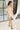 Full body front view of model wearing the Love Song Beige Off-The-Shoulder Mini Dress that has beige fabric, mini length, a pleated neckline, and off-the-shoulder pleated short sleeves.