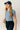 Front view of model wearing the Jolie Blue Cropped Short Sleeve Top that has blue knit fabric, a cropped waist, a round neckline and short sleeves.