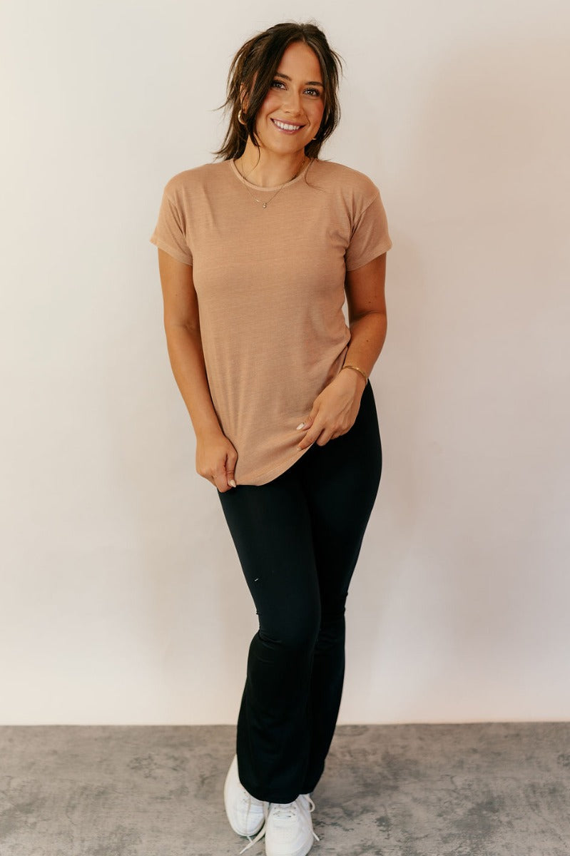 Full body view of model wearing the Sienna Taupe Basic Short Sleeve Top which features taupe knit fabric, a scooped hem, a round neckline and short sleeves.