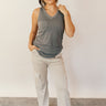 Full body front view of model wearing the Hadley Charcoal V-Neck Pocket Tank that has charcoal grey knit fabric, a scooped hem, a front right chest pocket with raw hem, a v-neck, and a racerback design.